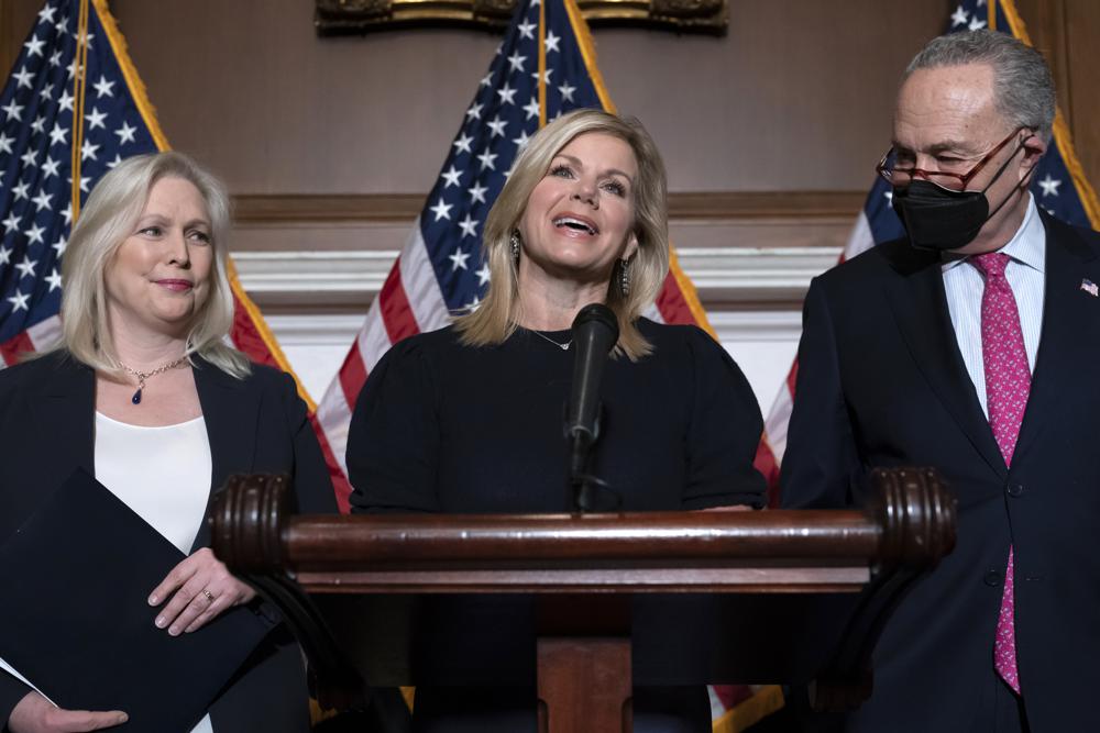 Former Fox News anchor Gretchen Carlson, center, celebrates with Sen. Kirsten Gillibrand, D-N.Y., left, and Senate Majority Leader Chuck Schumer, D-N.Y., at the Capitol in Washington, Thursday, after Congress gave final approval to legislation guaranteeing that people who experience sexual harassment at work can seek recourse in the courts.