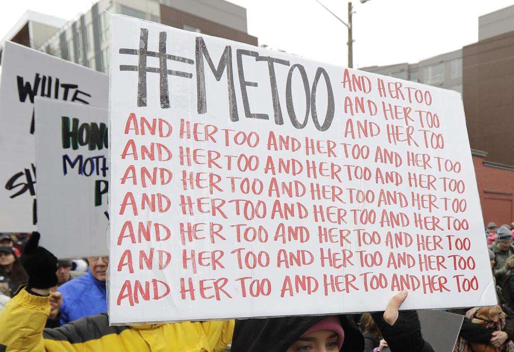 A marcher carries a sign with the popular Twitter hashtag #MeToo used by people speaking out against sexual harassment as she takes part in a Women's March in Seattle, Jan. 20, 2018.