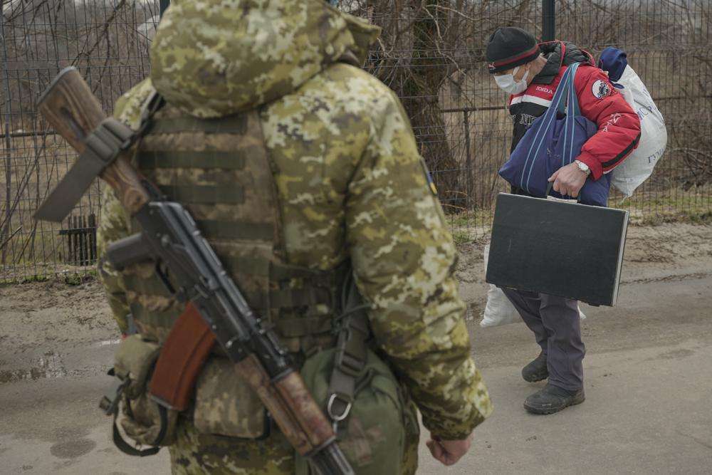 An elderly man holds his luggage as he crosses from pro-Russian separatists to Ukrainian government controlled territory in Stanytsia Luhanska, the only crossing point which is open daily, in the Luhansk region, eastern Ukraine, Friday.