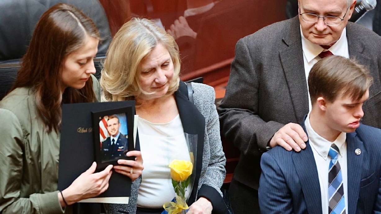 Hannah Allen holds a photo of her late husband, 1st. Lt. Kage Allen, while accompanied by his parents, Deborah and Mark Allen, and his brother, Stephen Allen, as members of the Utah House honor fallen members of the military at the Capitol in Salt Lake City on Friday. Allen died when his F-15 went down in the North Sea.