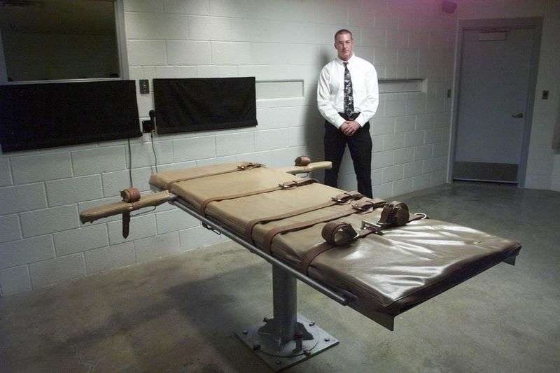 A Utah Department of Corrections prison officer stands
over the table in the execution chamber where Jospeh Parsons was
executed shortly after midnight on Oct. 15, 1999.