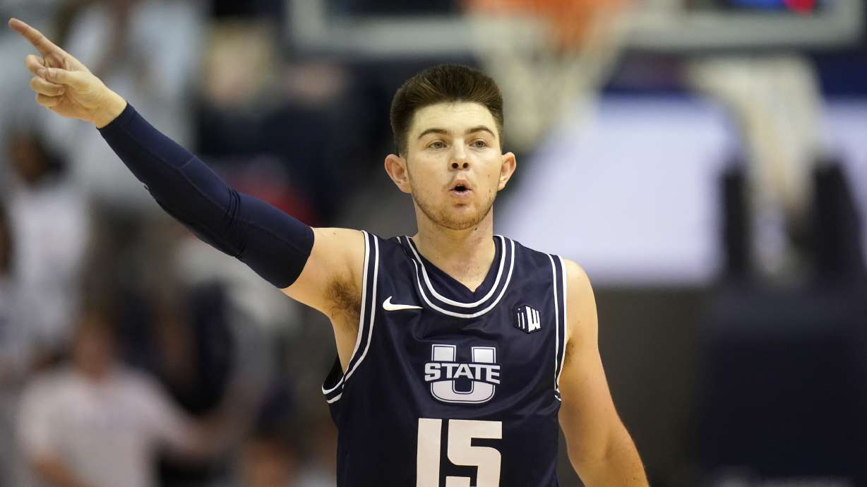 Utah State guard Rylan Jones (15) directs his team in the first half during an NCAA college basketball game against BYU Wednesday, Dec. 8, 2021, in Provo, Utah.