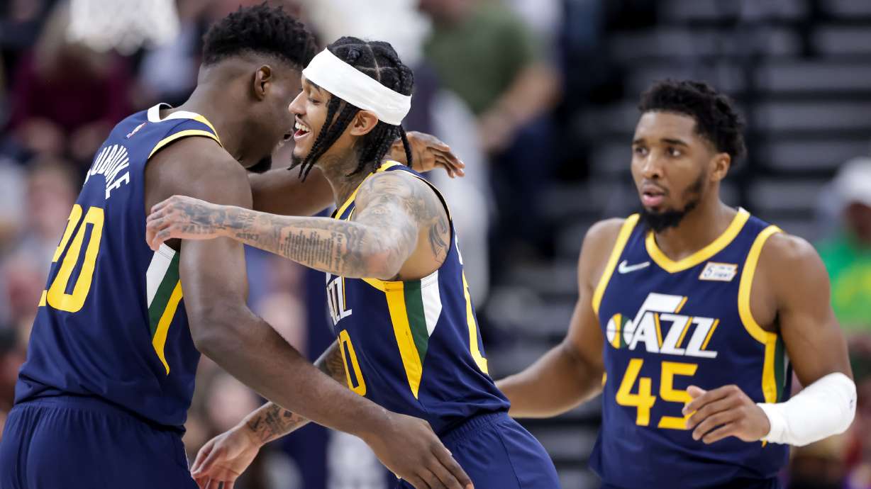 Utah Jazz center Udoka Azubuike (20) and guard Jordan Clarkson (00) hug after Azubuike slammed home a big dunk during the game against the Orlando Magic at Vivint Arena in Salt Lake City on Friday, Feb. 11, 2022.