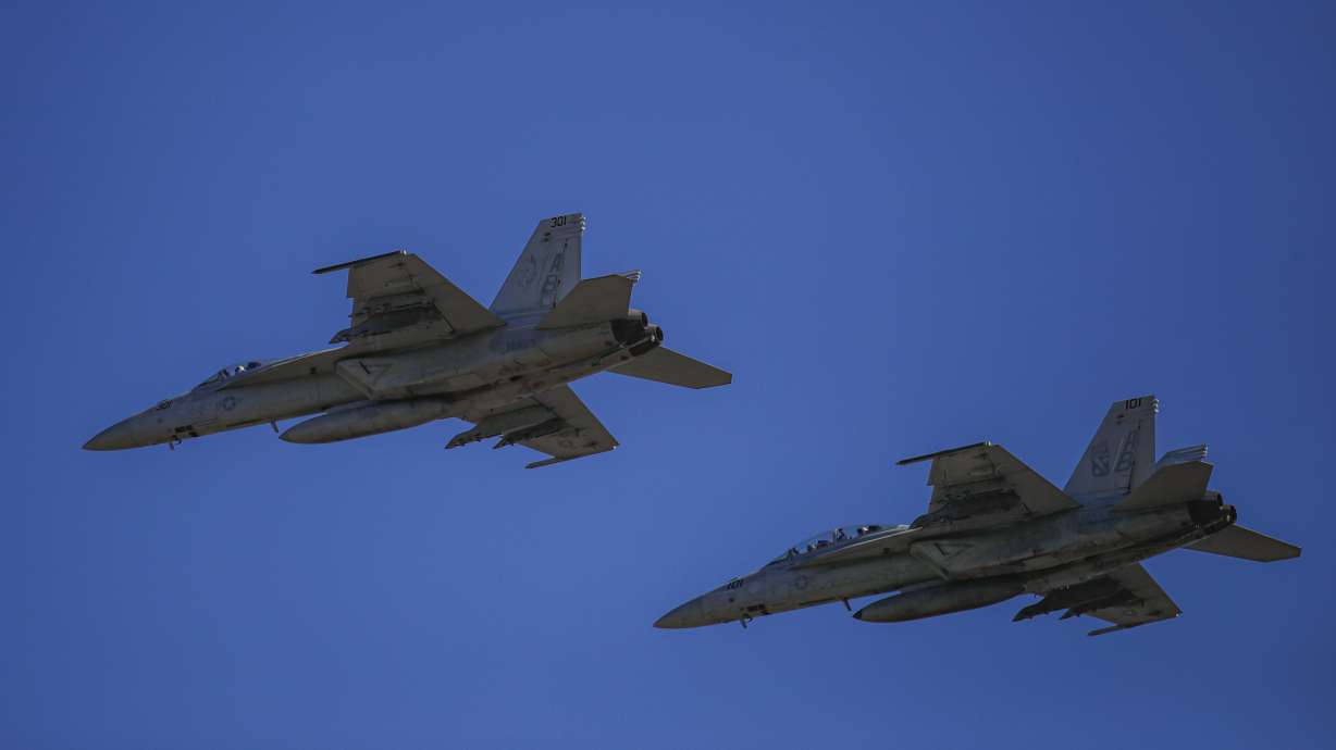 US Navy fighter jets fly during the visit of NATO Secretary-General Jens Stoltenberg at the Mihail Kogalniceanu airbase, near the Black Sea port city of Constanta, eastern Romania, Friday. President Joe Biden on Saturday again called on President Vladimir Putin to pull back more than 100,000 Russian troops massed near Ukraine's borders.