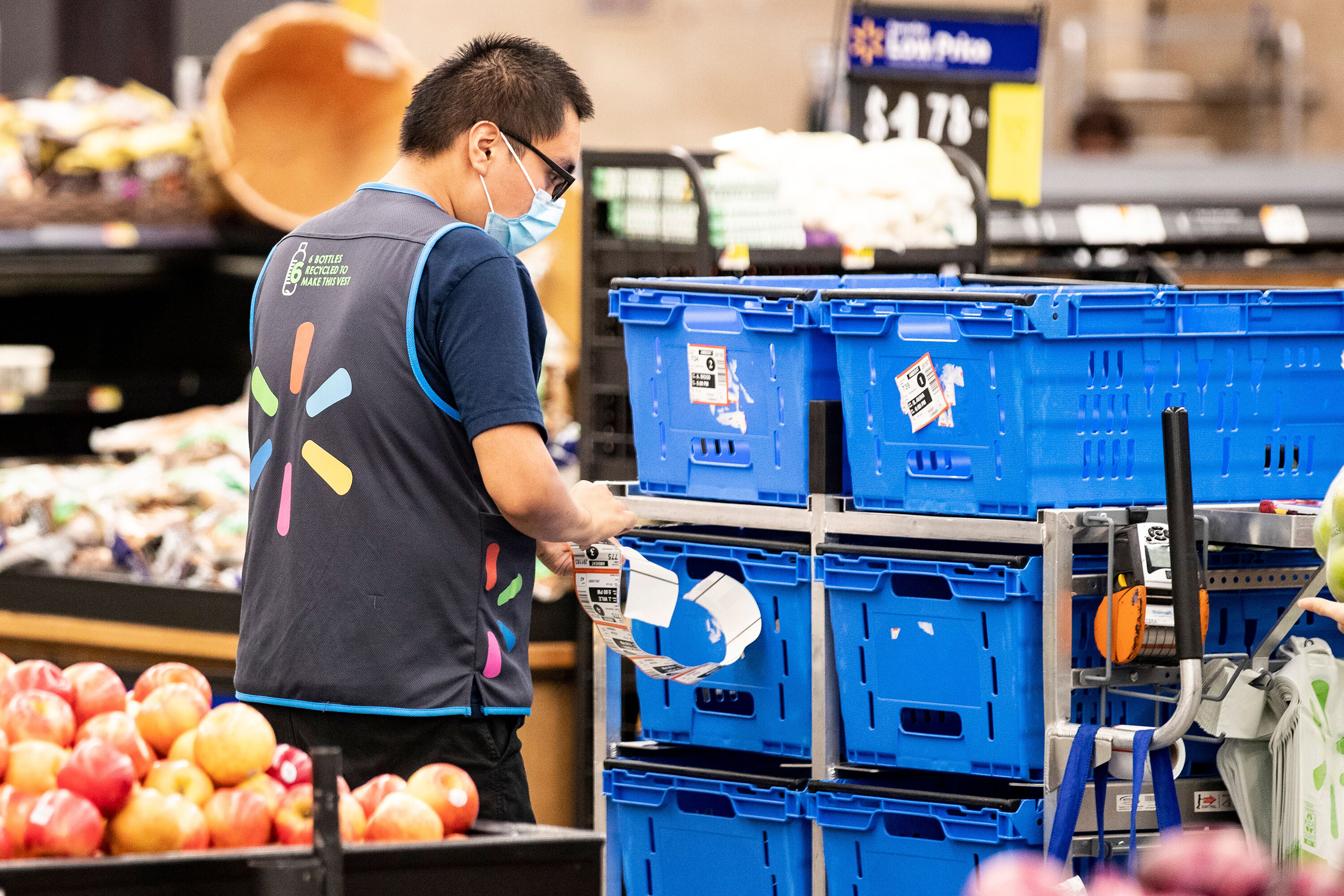 A Walmart employee wears a mask as he works in Burbank, California, July 15, 2020. Walmart updated its COVID-19 policy for U.S. associates Friday, dropping its mask mandate and COVID-19 sick leave policy.