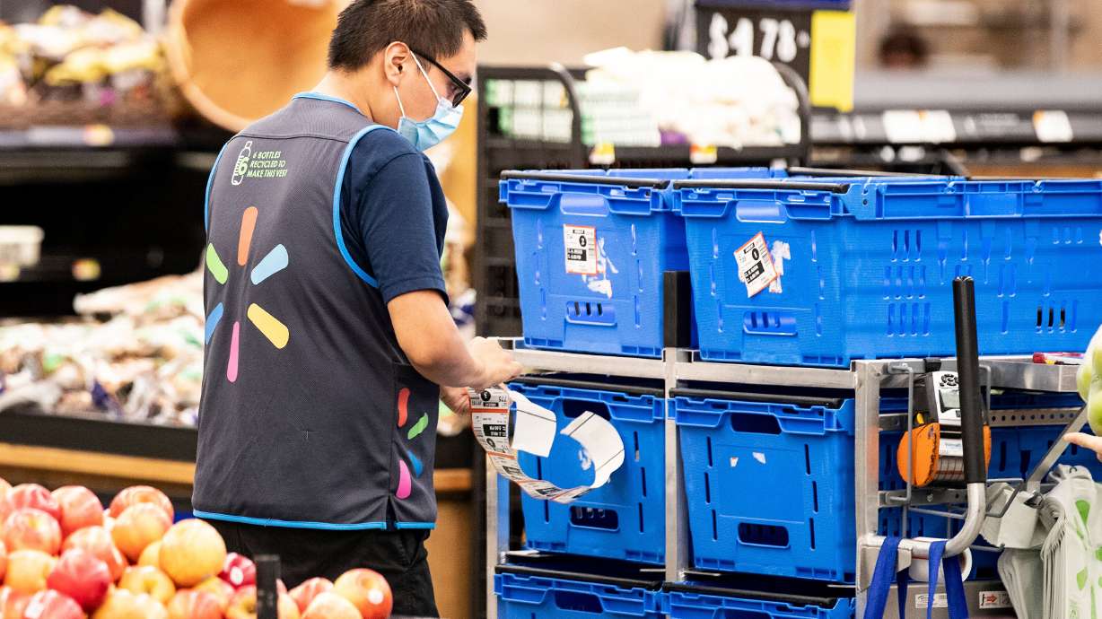 A Walmart employee wears a mask as he works in Burbank, California, July 15, 2020. Walmart updated its COVID-19 policy for U.S. associates Friday, dropping its mask mandate and COVID-19 sick leave policy.