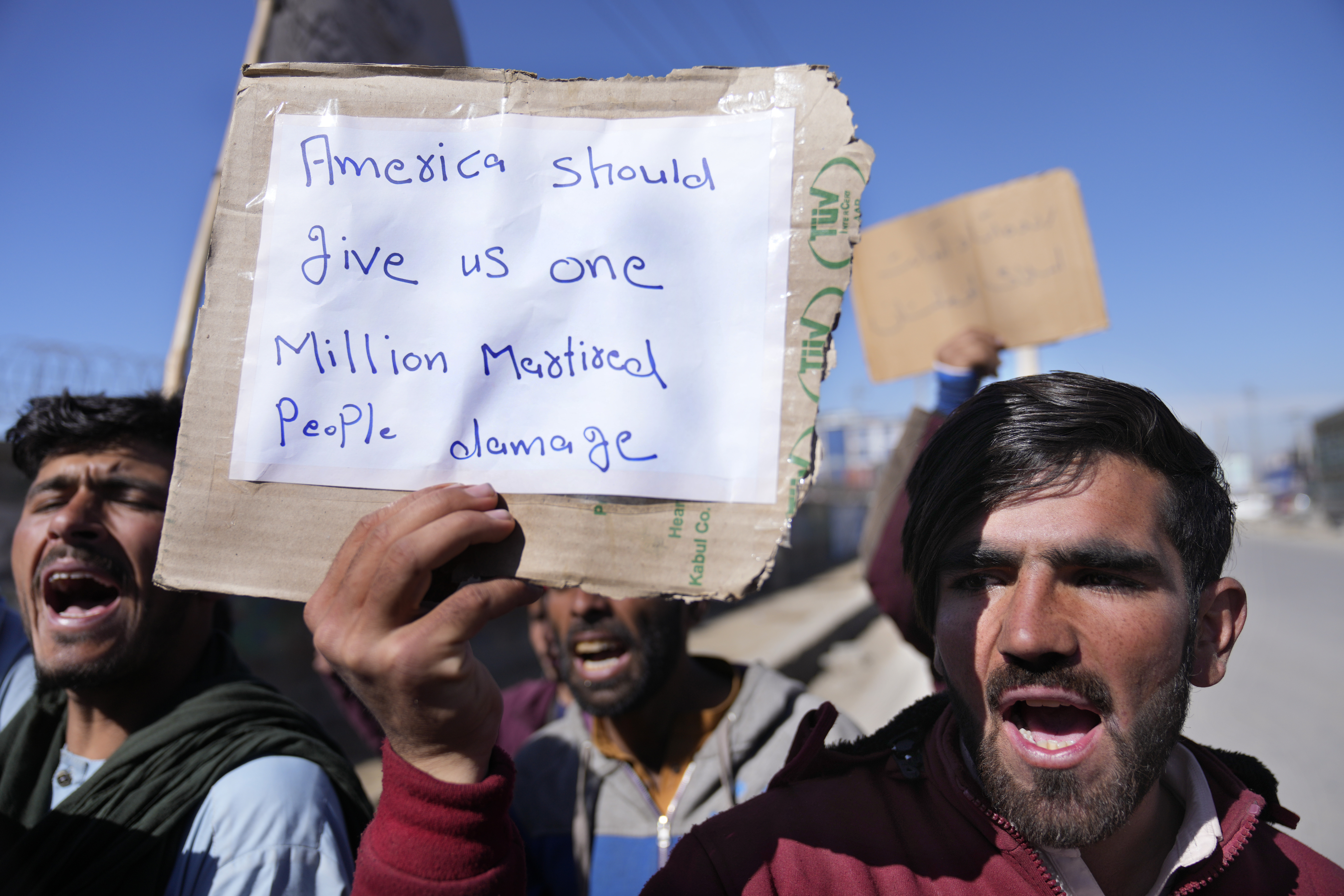 Afghan protesters hold placards and shout slogans against U.S. during a protest condemning President Joe Biden's decision, in Kabul, Afghanistan, Saturday. President Biden signed an executive order, Friday, to create a pathway to split $7 billion in Afghan assets frozen in the U.S. to fund humanitarian relief in Afghanistan and to create a trust fund to compensate Sept. 11 victims.