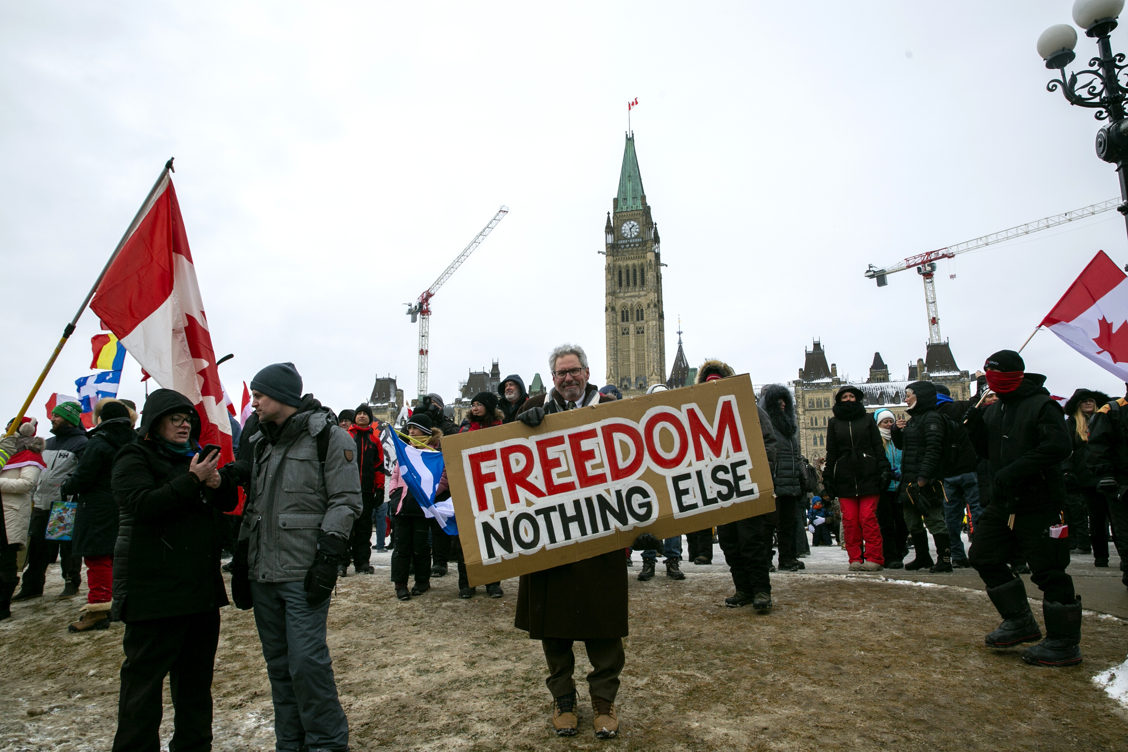 Don Stephens, 65, holds a sign to support trucks lined up in protest of COVID-19 vaccine mandates and restrictions in Ottawa, Ontario, on Saturday.The busiest U.S.-Canada border crossing was open Monday after protesters blocked it for nearly a week.