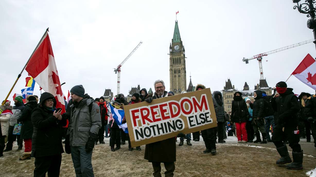 Don Stephens, 65, holds a sign to support trucks lined up in protest of COVID-19 vaccine mandates and restrictions in Ottawa, Ontario, on Saturday.The busiest U.S.-Canada border crossing was open Monday after protesters blocked it for nearly a week.