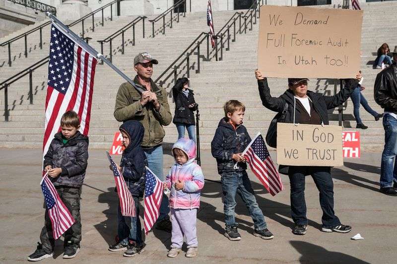 Members of a family who were not willing to provide
their names hold signs and U.S. flags during a rally calling for a
forensic vote audit at the Capitol in Salt Lake City on Wednesday,
Oct. 20, 2021. Utahns are split over whether the 2020 election should be audited.