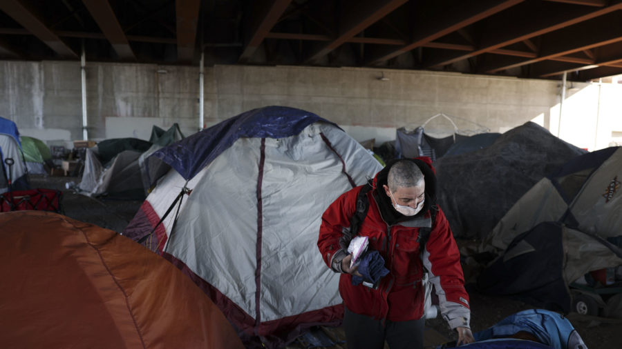 Tony Lambert  moves some of his belongings at his homeless encampment in Salt Lake City on Feb. 2.