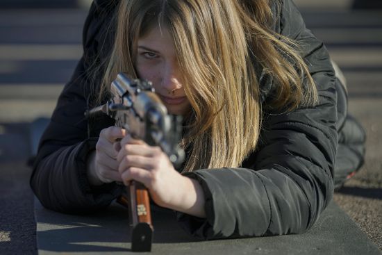 A young woman holds a weapon during a basic combat training for civilians, organized by the Special Forces Unit Azov, of Ukraine's National Guard, in Mariupol, Donetsk region, eastern Ukraine, Sunday.