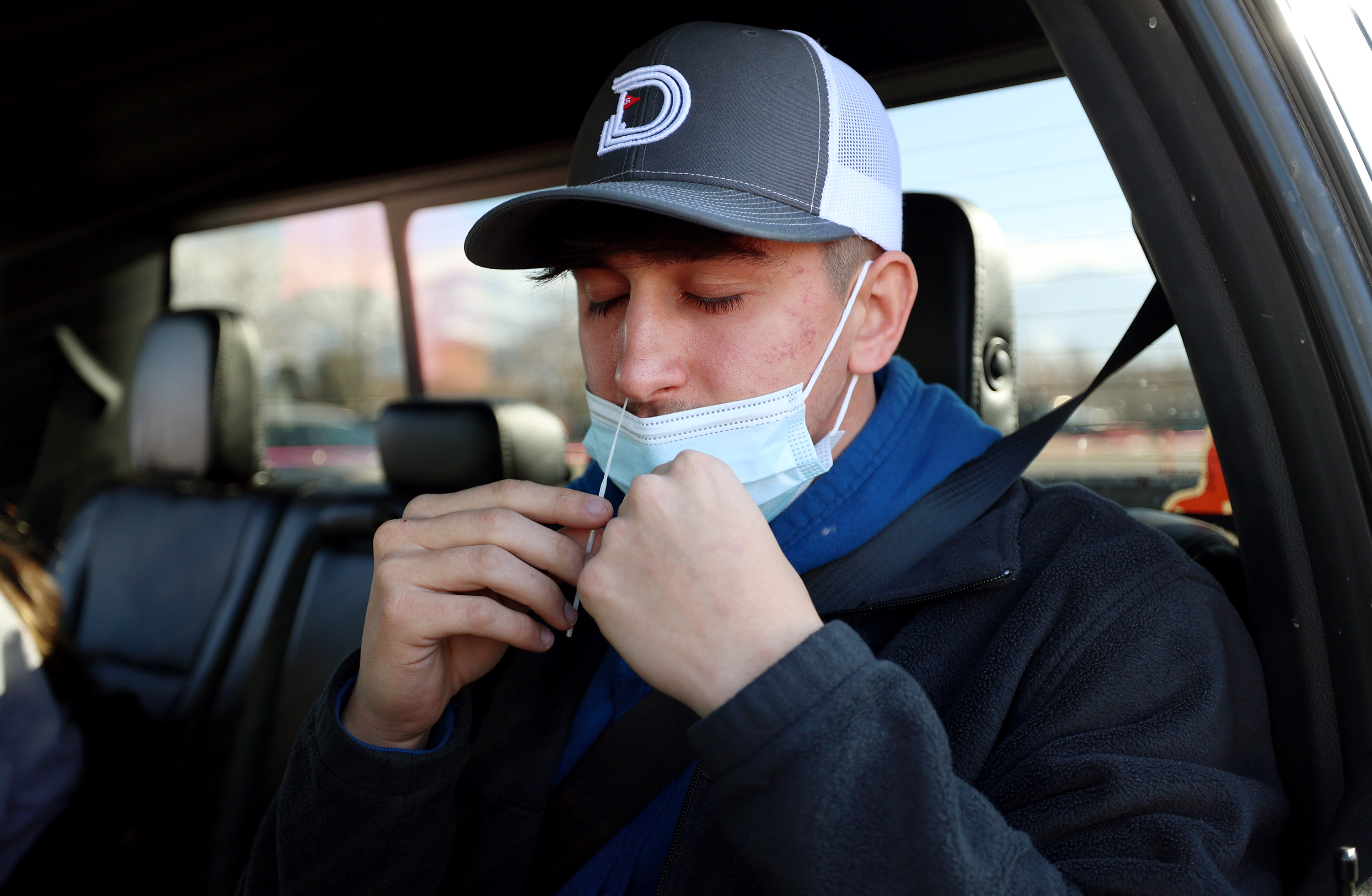 Nathan Graham tries not to sneeze as he swabs his nose for a COVID-19 test at the University of Utah in Salt Lake City on Jan. 31. Utah reported over 3,000 new COVID-19 cases on Monday and 39 deaths.
