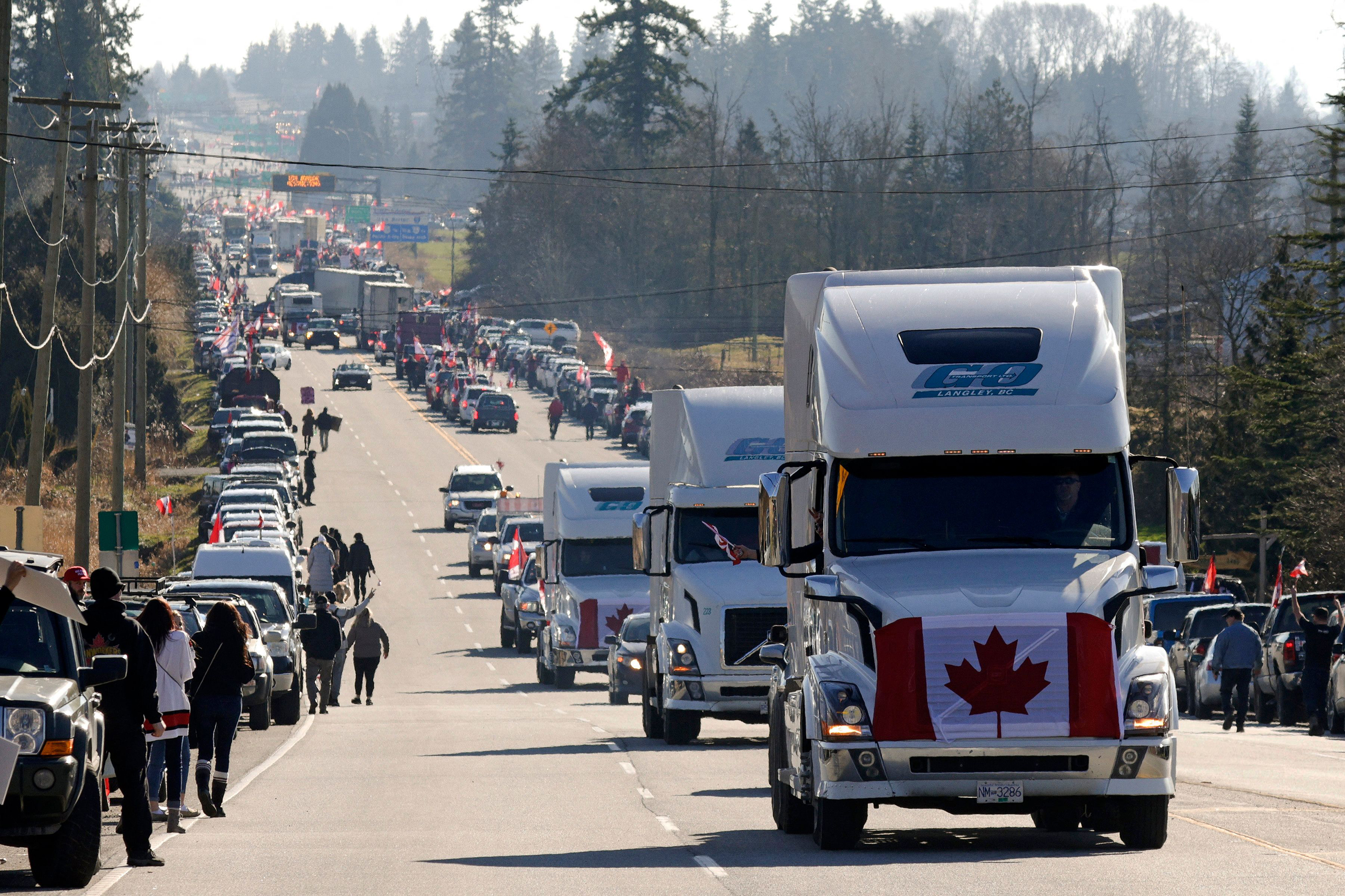 Trucks drive by as anti-vaccine mandate and anti-government protesters demonstrate on Highway 15 near the Pacific Highway Border Crossing on the U.S.-Canada border with Washington State in Surrey, British Columbia, Canada, on Saturday. On Monday, police said they seized guns and ammunition from protesters.