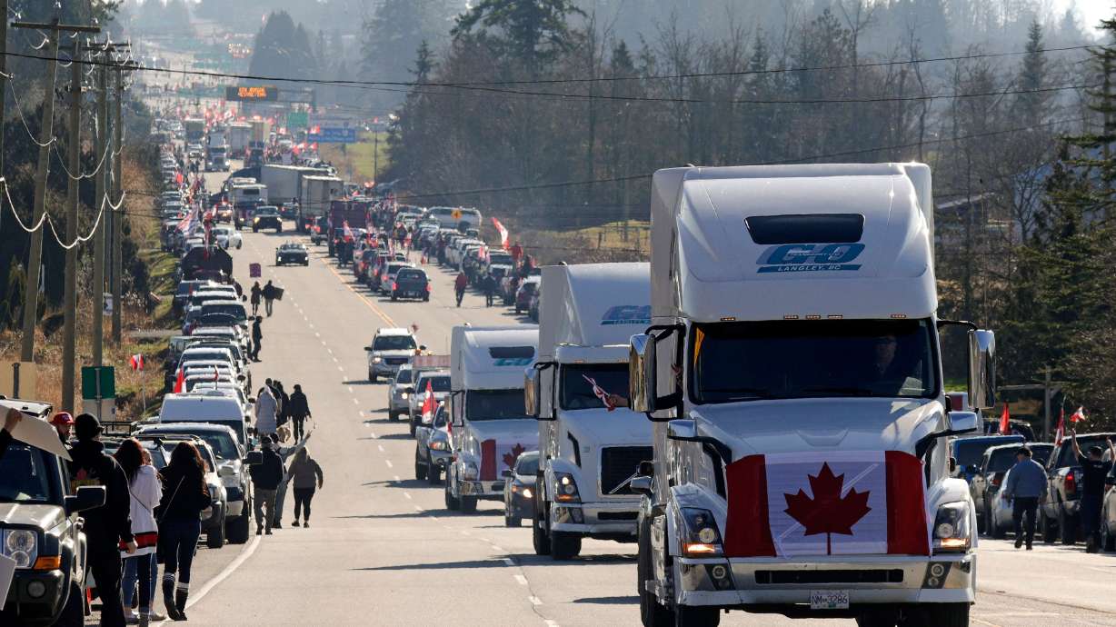 Trucks drive by as anti-vaccine mandate and anti-government protesters demonstrate on Highway 15 near the Pacific Highway Border Crossing on the U.S.-Canada border with Washington State in Surrey, British Columbia, Canada, on Saturday. On Monday, police said they seized guns and ammunition from protesters.