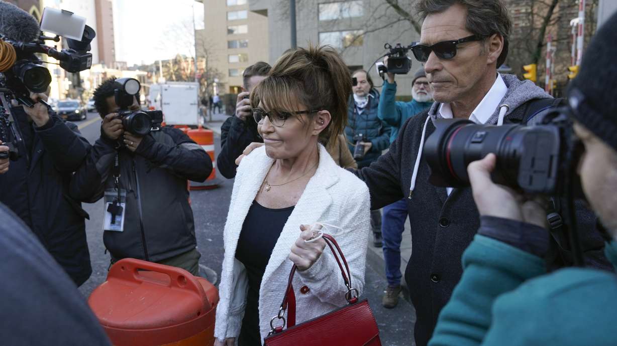 Former Alaska Gov. Sarah Palin is escorted to her car by Ron Duguay after leaving the courthouse in New York, on Feb. 10. A judge said Monday he'll dismiss a libel lawsuit that Palin filed against The New York Times.