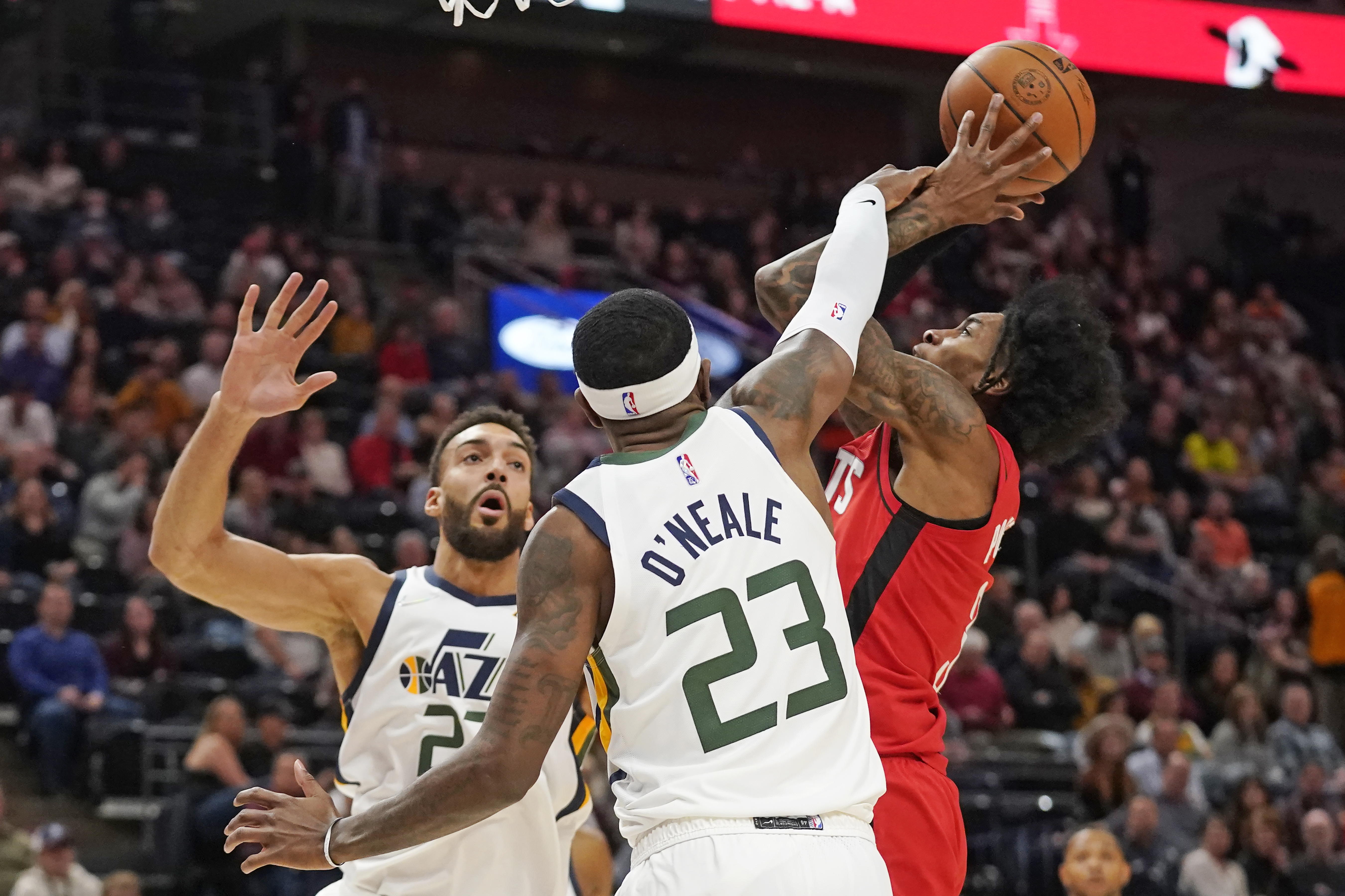 Houston Rockets guard Kevin Porter Jr., right, is fouled by Utah Jazz forward Royce O'Neale (23) as he goes to the basket during the first half of an NBA basketball game Monday, Feb. 14, 2022, in Salt Lake City.