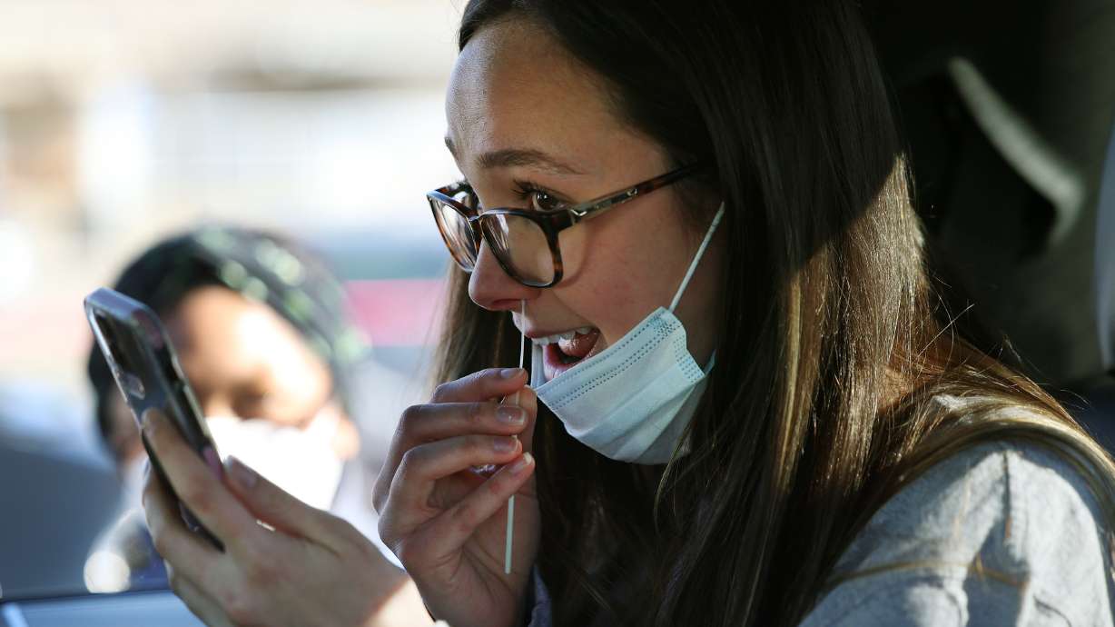 Caiden Bishop swabs her nose for a COVID-19 test at the University of Utah in Salt Lake City, Jan. 31. On Friday, Utah health officials reported 21 COVID-19 deaths and 244 new cases.