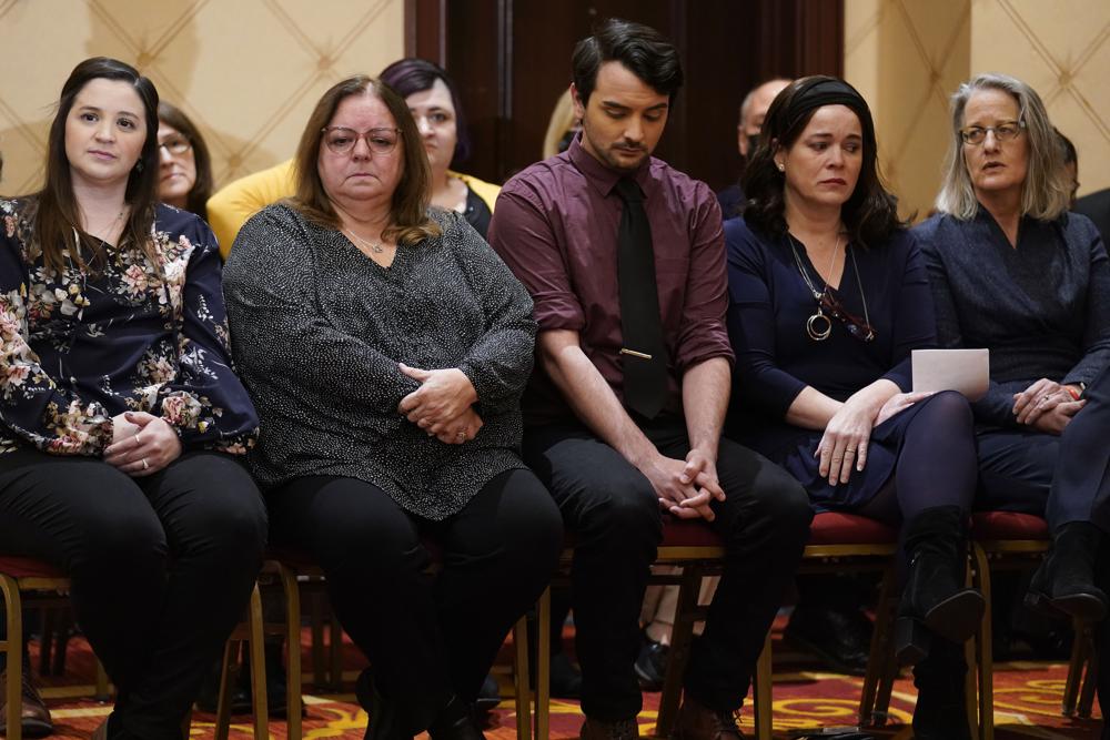 Families of the victims of the Newtown shooting and attorneys listen during a news conference in Trumbull, Conn., Tuesday. The families of nine victims of the Sandy Hook Elementary School shooting have agreed to a $73 million settlement of a lawsuit against the maker of the rifle used to kill 20 first graders and six educators in 2012, their attorney said Tuesday. 