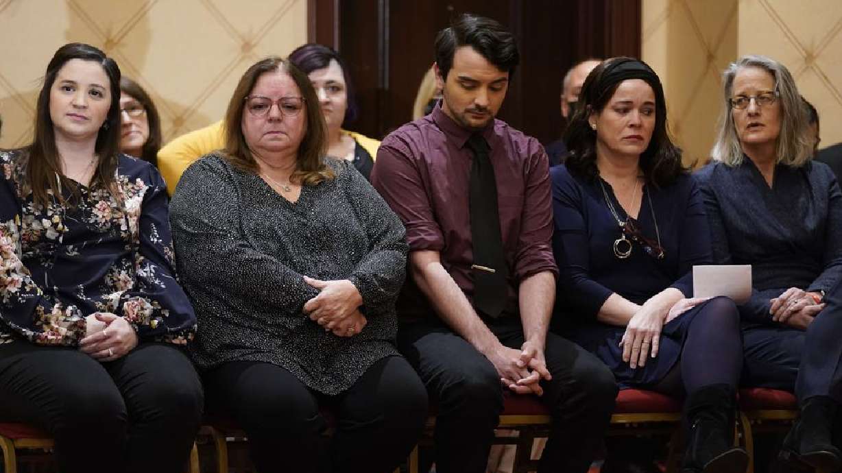 Families of the victims of the Newtown shooting and attorneys listen during a news conference in Trumbull, Conn., Tuesday. The families of nine victims of the Sandy Hook Elementary School shooting have agreed to a $73 million settlement of a lawsuit against the maker of the rifle used to kill 20 first graders and six educators in 2012, their attorney said Tuesday.