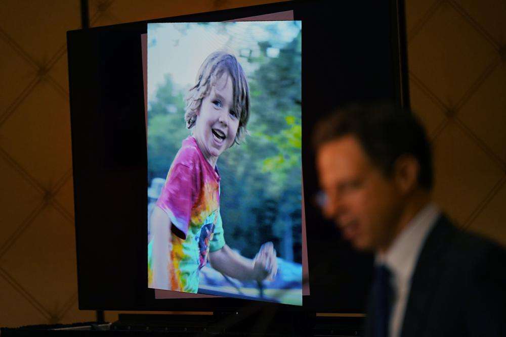 A photo of Daniel Barden, who was killed during the shooting in Sandy Hook Elementary School, is displayed while attorney Josh Koskoff speaks during a news conference in Trumbull, Conn., Tuesday. The families of nine victims of the Sandy Hook Elementary School shooting have agreed to a $73 million settlement of a lawsuit against the maker of the rifle used to kill 20 first graders and six educators in 2012, their attorney said Tuesday.