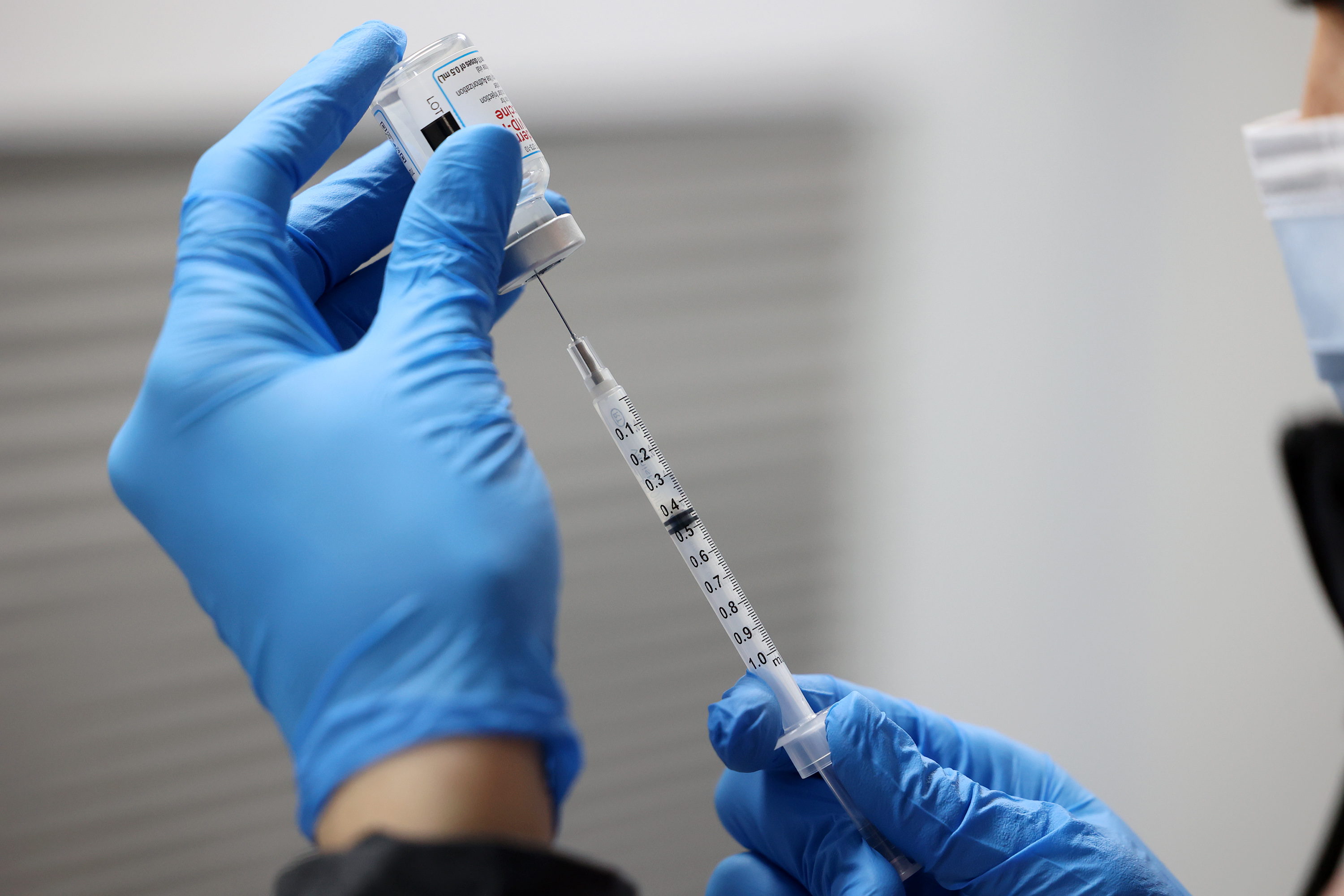 Christine Spencer fills a syringe with the Moderna COVID-19 vaccine at a Salt Lake County Health Department mobile site at Tejeda's Market in Salt Lake City on Dec. 29, 2021. Utah health officials reported another 10 deaths and 1,392 COVID-19 cases on Wednesday.