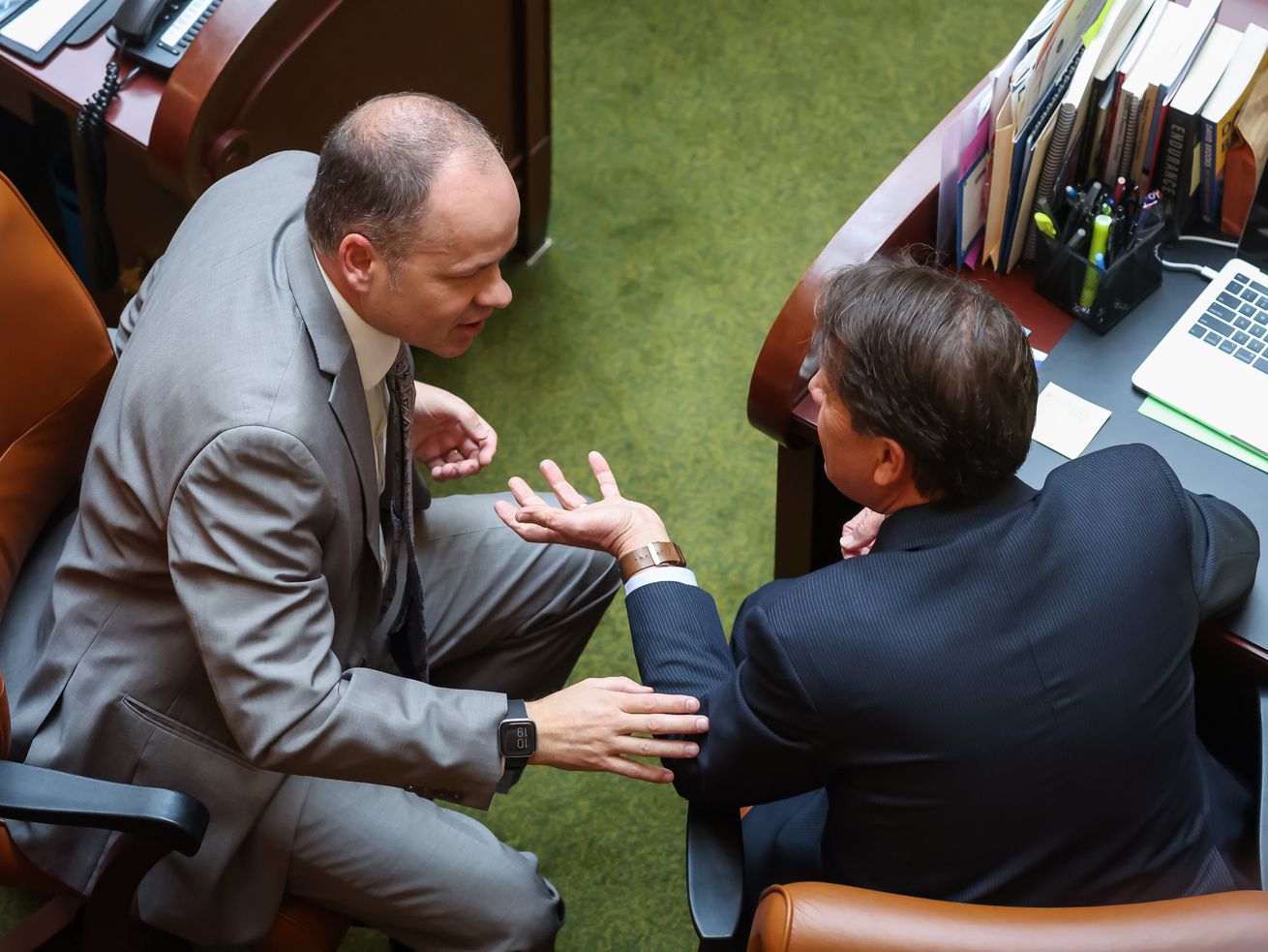 Rep. Timothy Hawkes, R-Centerville, and Rep. Keven Stratton, R-Orem, talk on the House floor at the Capitol in Salt Lake City on Wednesday.