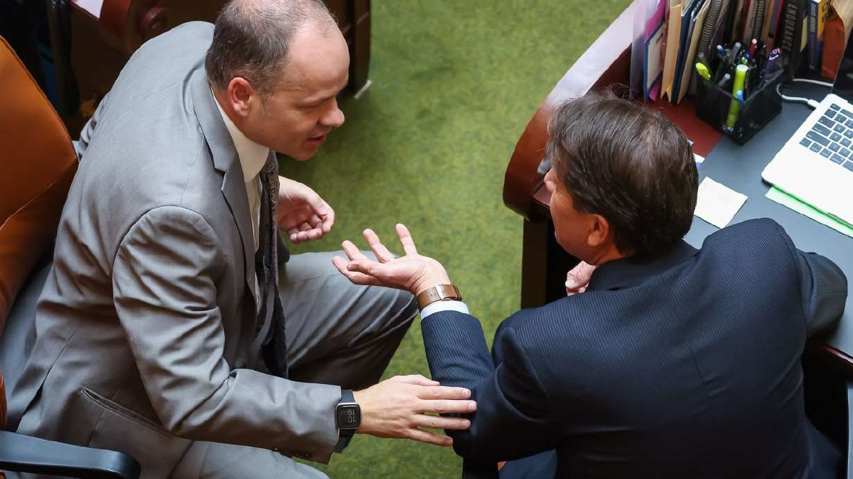 Rep. Timothy Hawkes, R-Centerville, and Rep. Keven Stratton, R-Orem, talk on the House floor at the Capitol in Salt Lake City on Wednesday.