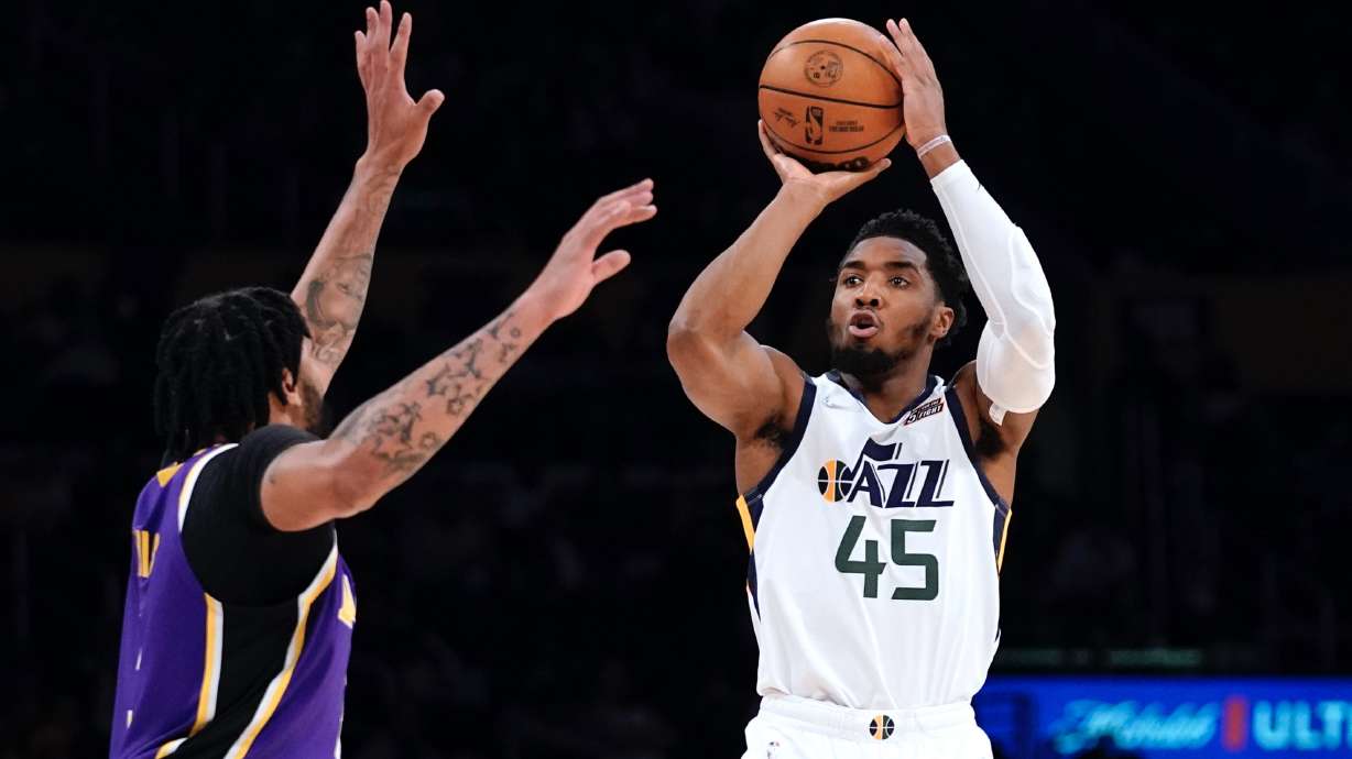 Utah Jazz guard Donovan Mitchell, right, shoots as Los Angeles Lakers forward Anthony Davis defends during the first half of an NBA basketball game Wednesday, Feb. 16, 2022, in Los Angeles.