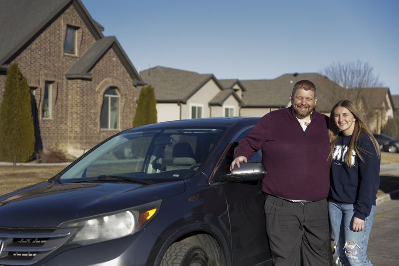 West Brewer, left, and his daughter, Ally Brewer, pose
for a portrait with her new car in Herriman on Friday, Feb. 11.