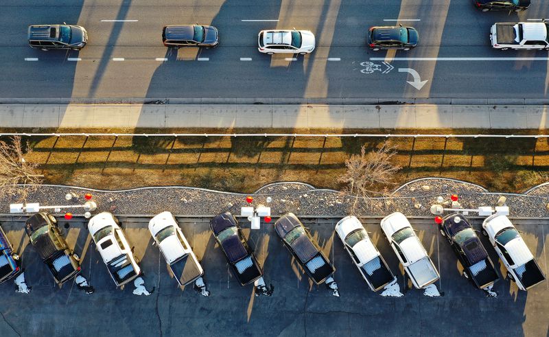 Motorists drive on State Street as trucks are lined up
for sale at Low Book Sales in Lindon on Thursday, Feb. 3.