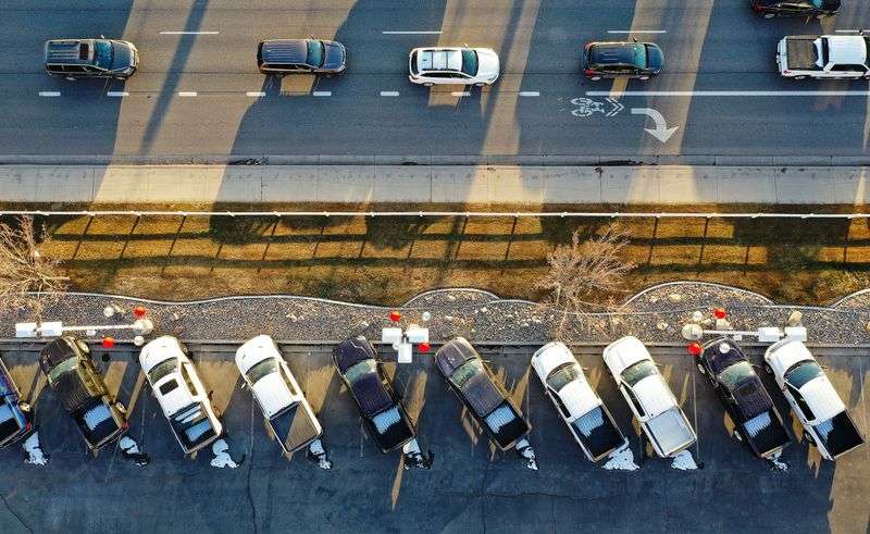 Motorists drive on State Street as trucks are lined up
for sale at Low Book Sales in Lindon on Thursday, Feb. 3.