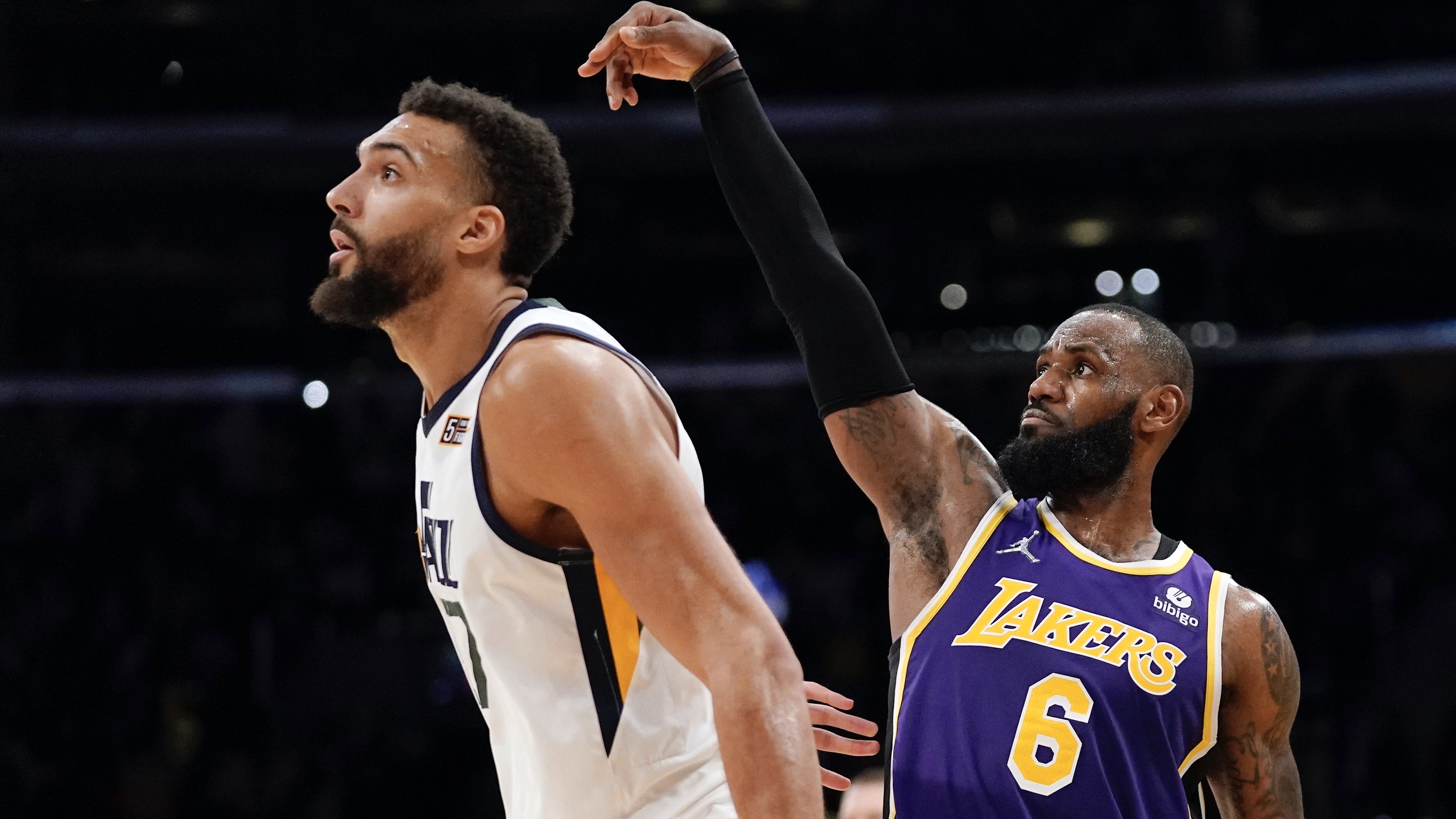 Los Angeles Lakers forward LeBron James, right, watches along with Utah Jazz center Rudy Gobert as his three-point shot goes in during the second half of an NBA basketball game Wednesday, Feb. 16, 2022, in Los Angeles. The Lakers won 106-101.