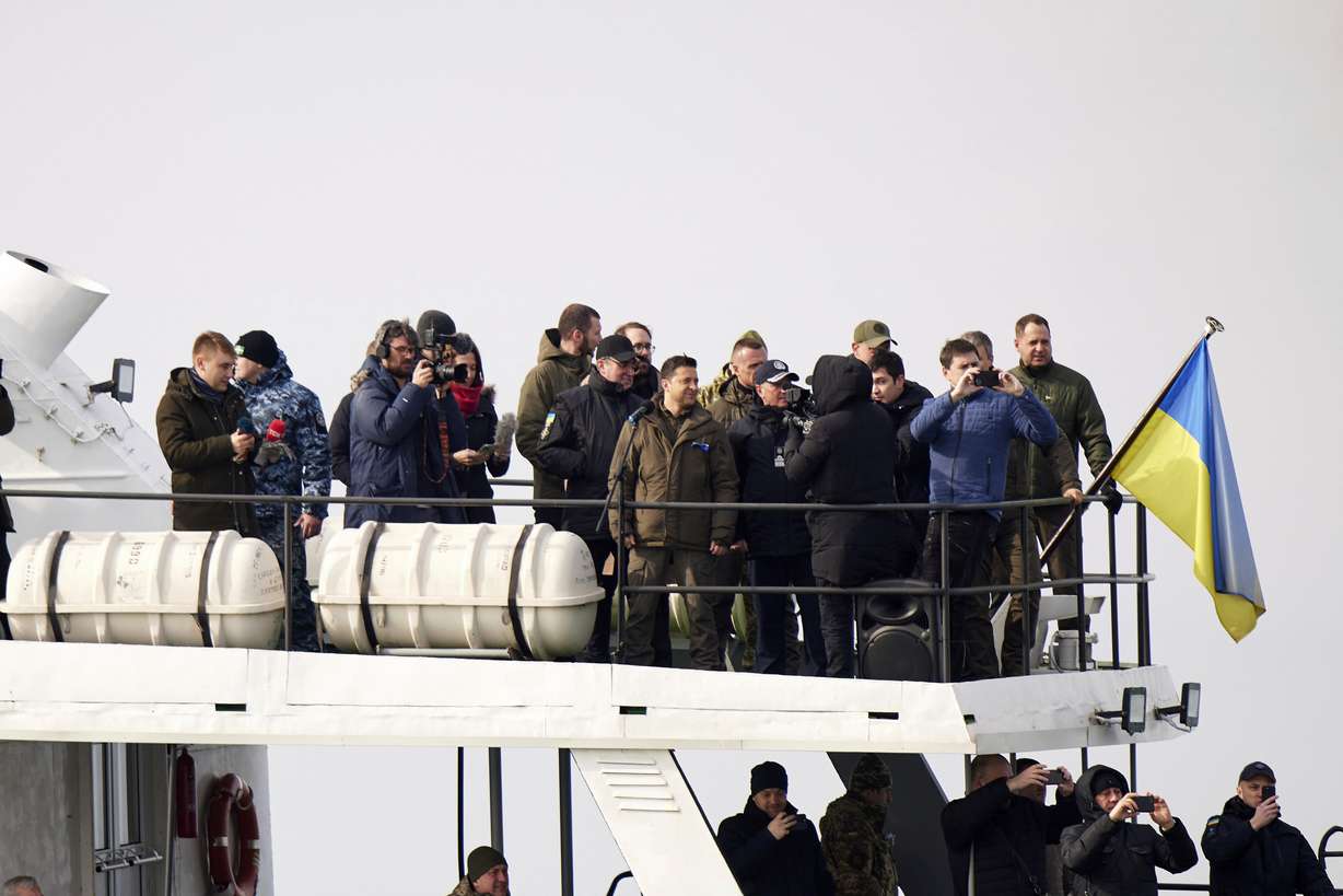 Ukrainian President Volodymyr Zelenskyy, center-top, stands on boat during his visit to the Ukrainian coast guard, in Mariupol, Donetsk region, eastern Ukraine, Thursday.