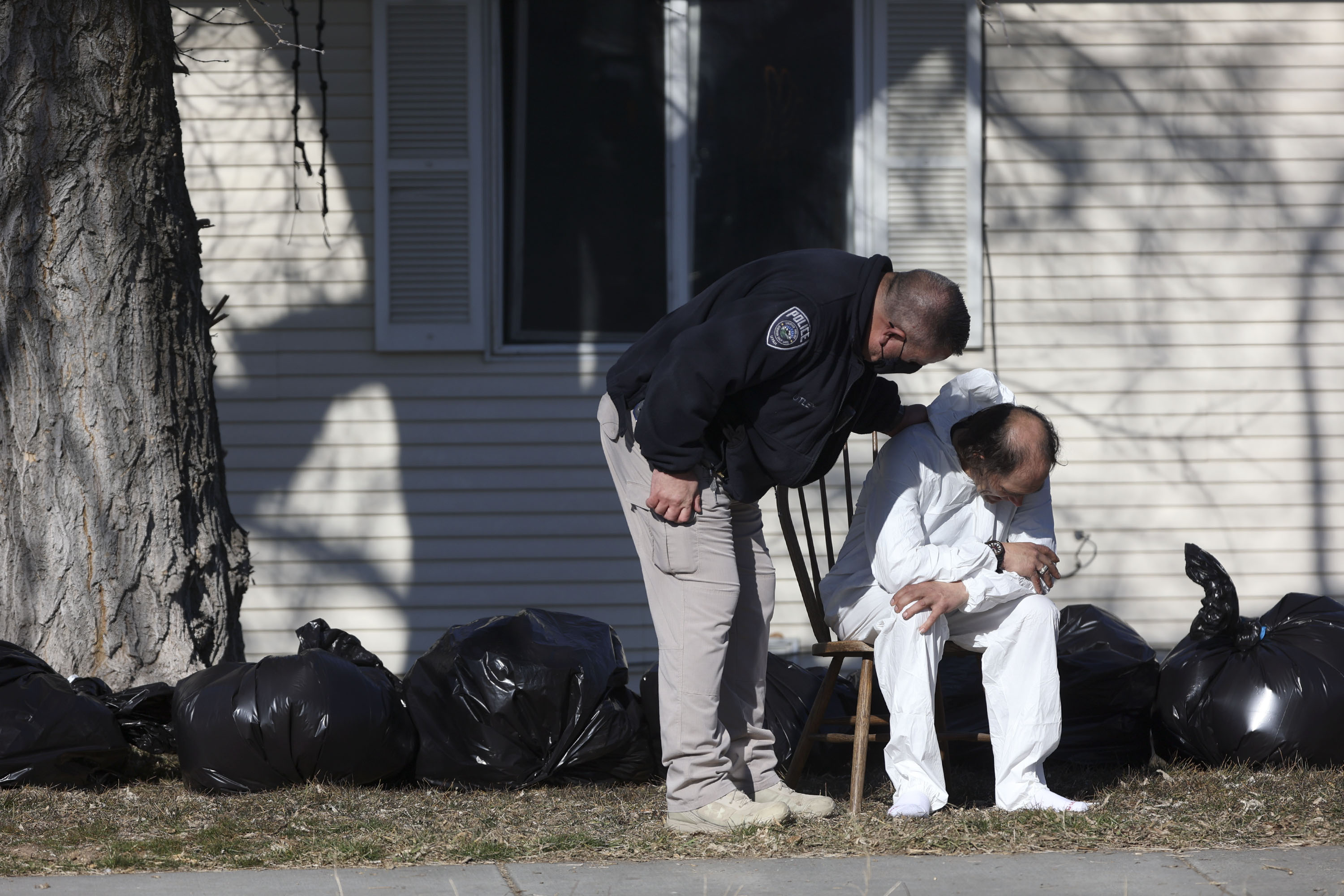 A Unified police officer talks to an Evergreen Place resident as he wears a hazardous materials suit and sits outside of Evergreen Place, an assisted living facility, as the facility gets shut down due to health violations on Jan. 26. Court documents describe how residents went without heat and with a broken sewage line.