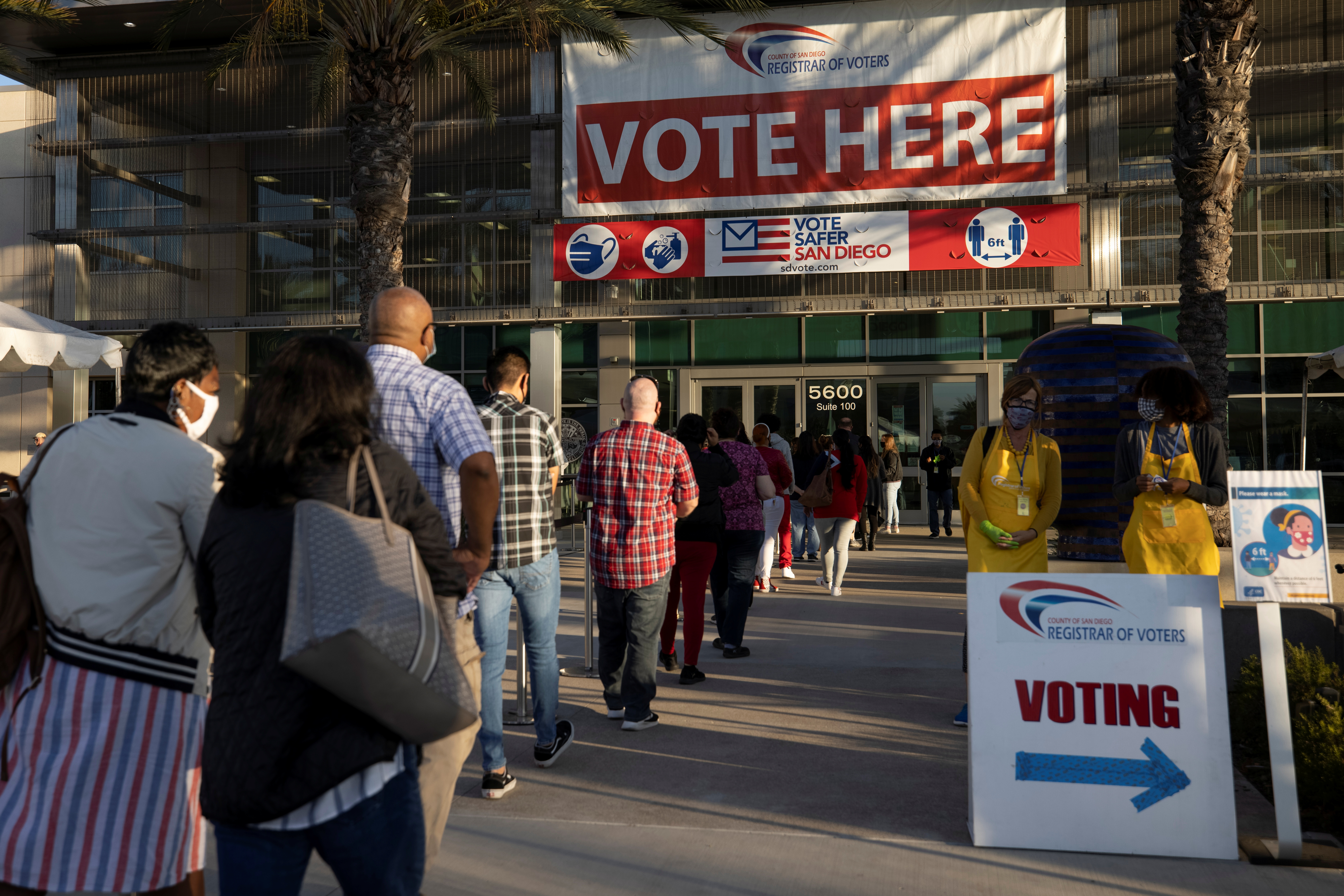 Poll workers wait in line to grab breakfast prior to the polls opening at the Registrar of Voters on the day of the U.S. Presidential election in San Diego, Nov. 3, 2020. Lawmakers in Oregon and California are calling for tougher legislation to protect election workers in response to a continuing wave of threats and harassment.
