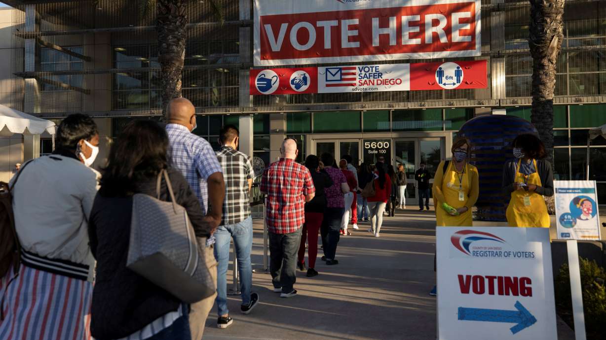 Poll workers wait in line to grab breakfast prior to the polls opening at the Registrar of Voters on the day of the U.S. Presidential election in San Diego, Nov. 3, 2020. Lawmakers in Oregon and California are calling for tougher legislation to protect election workers in response to a continuing wave of threats and harassment.