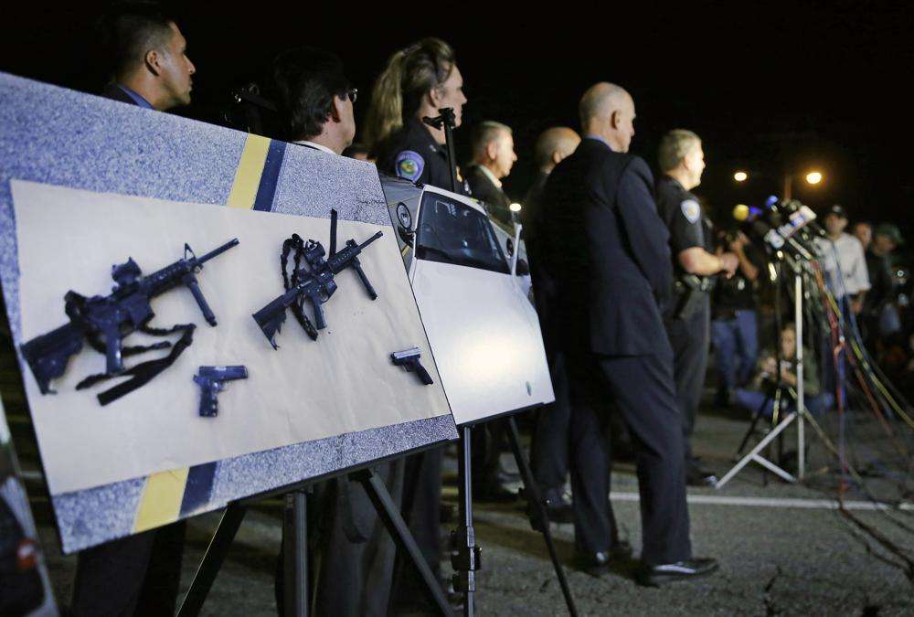 In this Thursday, Dec. 3, 2015 photo, police crime photos of assault rifles and handguns are displayed during a news conference near the site of a mass shooting in San Bernardino, Calif. On Friday, California Gov. Gavin Newsom announced legislation aimed at letting private citizens file lawsuits to enforce a ban on assault weapons.