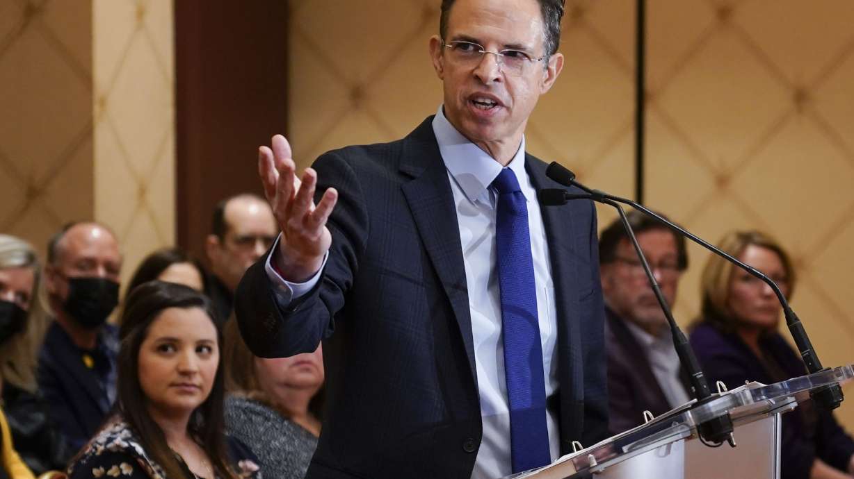 While families of the victims of the Sandy Hook Elementary School shooting look on, attorney Josh Koskoff speaks during a news conference in Trumbull, Conn., Tuesday, Feb. 15. After agreeing to a $73 million lawsuit settlement with gun-maker Remington, the families of nine Sandy Hook Elementary School shooting victims say they are shifting their focus to ending firearms advertising.