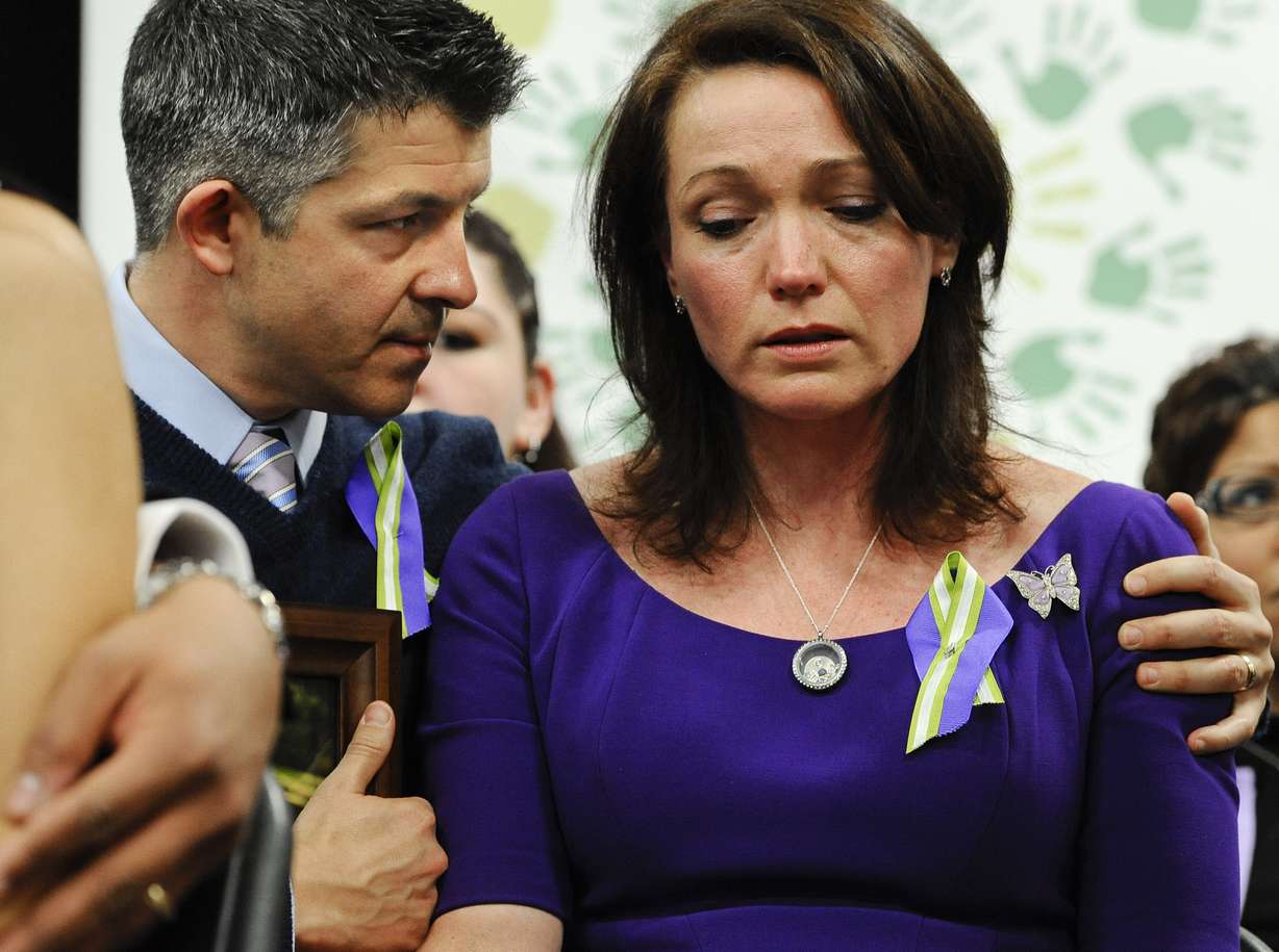 Ian and Nicole Hockley, parents of Sandy Hook School shooting victim Dylan, listen at a news conference at Edmond Town Hall in Newtown, Conn., Monday, Jan. 14, 2013. After agreeing to a $73 million lawsuit settlement with gun-maker Remington, the families of nine Sandy Hook Elementary School shooting victims say they are shifting their focus to ending firearms advertising.