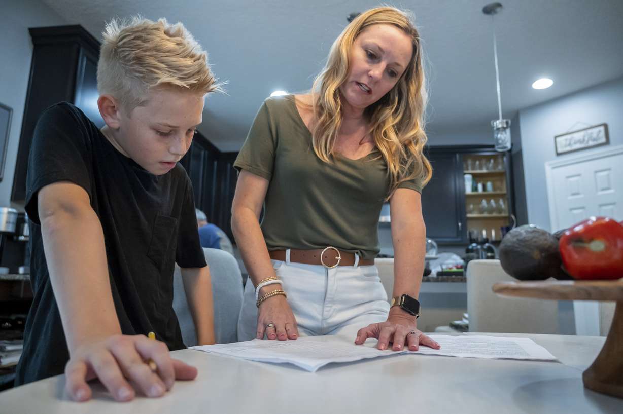 Colton Nover, 10, works on a report for school with his mother, Holly Nover in their kitchen Wednesday, in St. Johns, Fla. Both mother and son have an issue with stuttering.