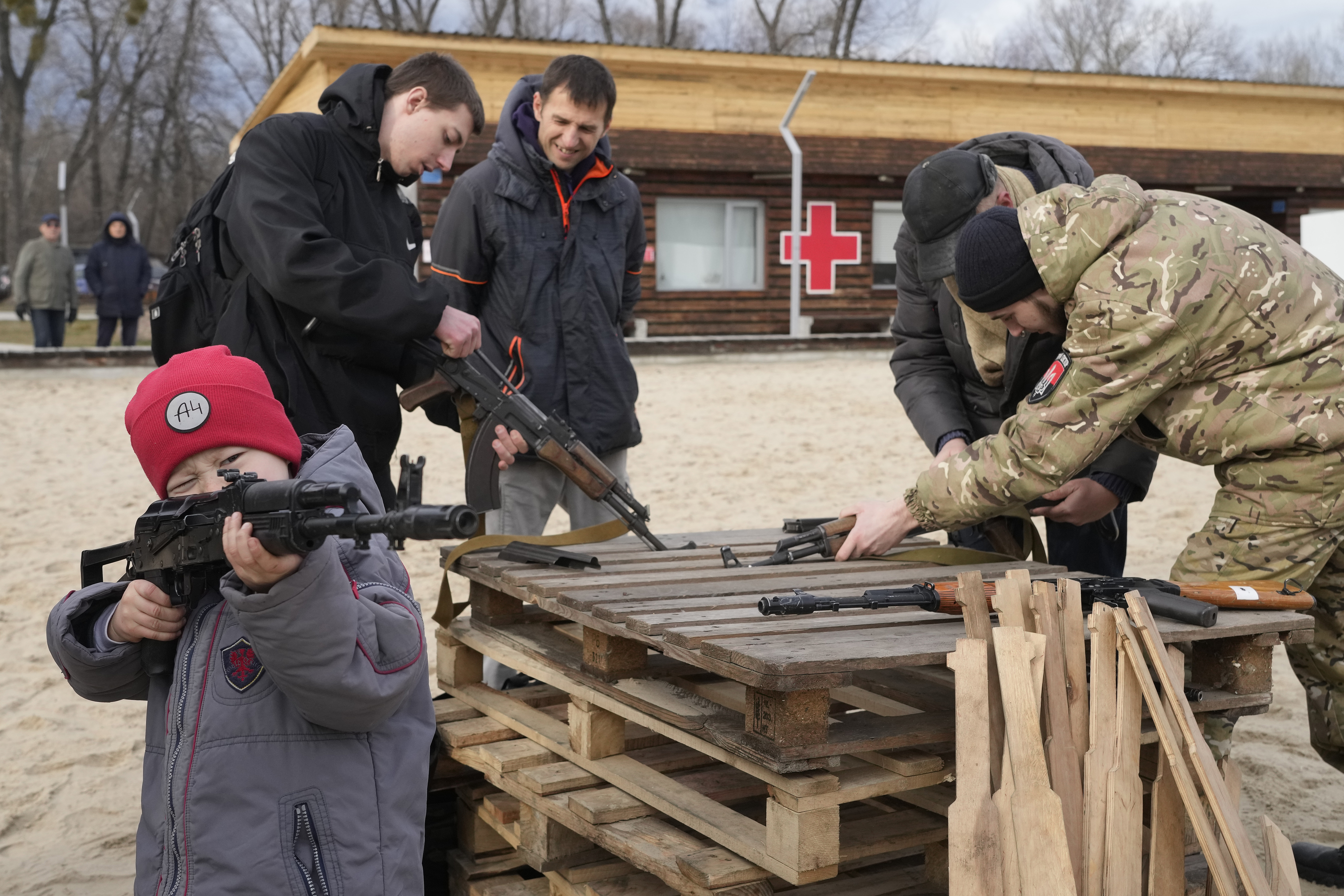 A boy plays with a weapon while an instructor shows a Kalashnikov assault rifle during a training of members of a Ukrainian far-right group train, in Kyiv, Ukraine, Sunday. 