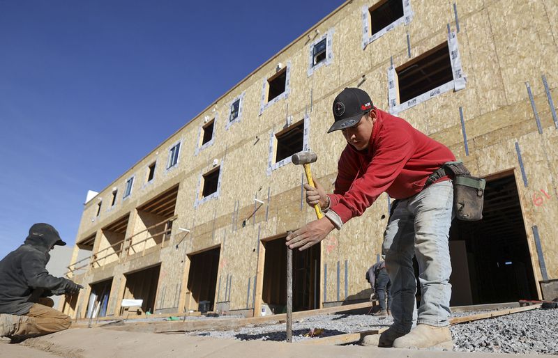 Omar Miranda, leader concrete carpenter, helps form
driveways for concrete for new town houses under construction at
Park Lofts at City Center, by Brighton Homes, in North Salt Lake on
Friday.