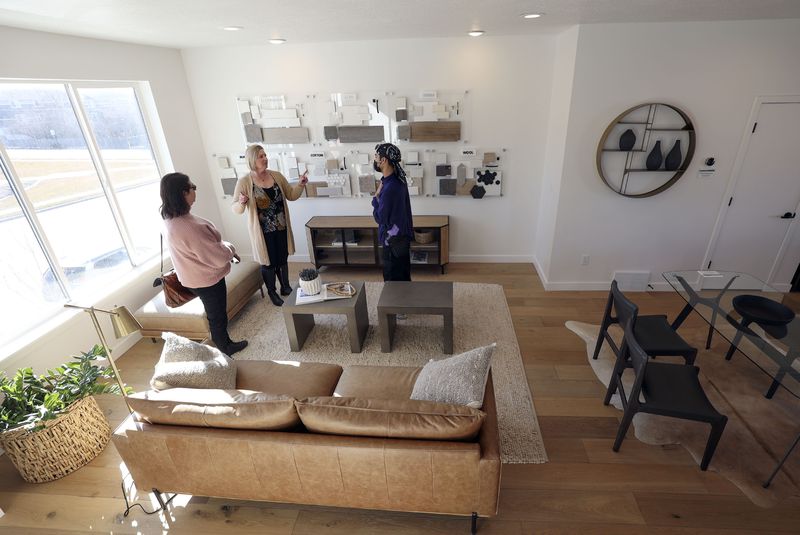 Coldwell Banker real estate agent Helene Kepas-Brown,
left, Brighton Homes sales agent Julie Blum and prospective buyer
Aaron Khan walk through a three bedroom, two-and-a-half bathroom
model unit town house at Park Lofts at City Center, by Brighton
Homes, in North Salt Lake on Friday.