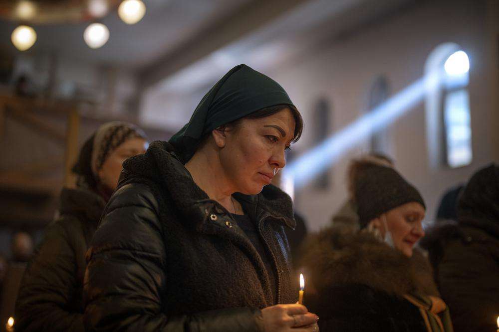 Women pray in Kyiv, during the funeral of army captain Anton Sydorov, 35, killed in eastern Ukraine, on Tuesday. Western leaders said Tuesday that Russian troops have moved into rebel-held areas in eastern Ukraine after President Vladimir Putin's recognized their independence — but some indicated it was not yet the long-feared full-fledged invasion as confusion reigned in the region.