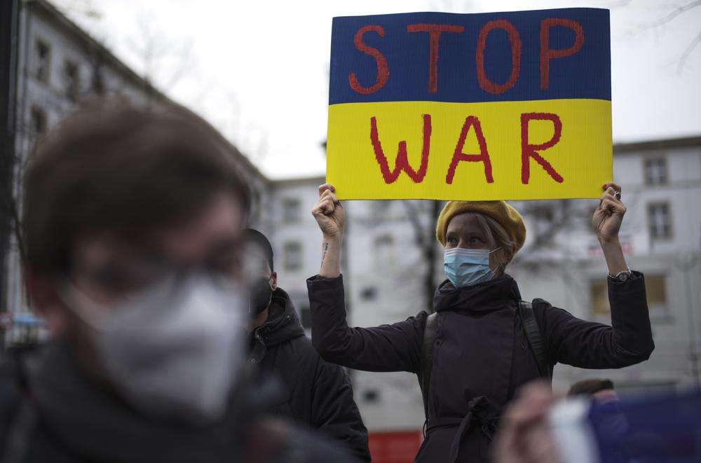 A woman with a poster attends a demonstration along the street near the Russian embassy to protest against the escalation of the tension between Russia and Ukraine in Berlin, Germany, Tuesday. Lawmakers gave Russian President Vladimir Putin permission to use military force outside the country on Tuesday.