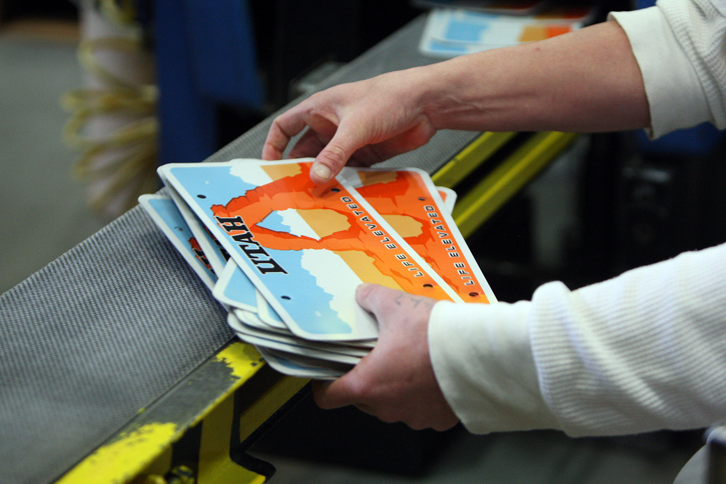 An inmate does quality control on license plates at the Utah State Prison in Draper on March 5, 2014. Under a bill that cleared the Utah House on Tuesday, the Utah Governor's Office would be in charge of any changes to Utah's primary license plates. The bill still needs Senate approval.