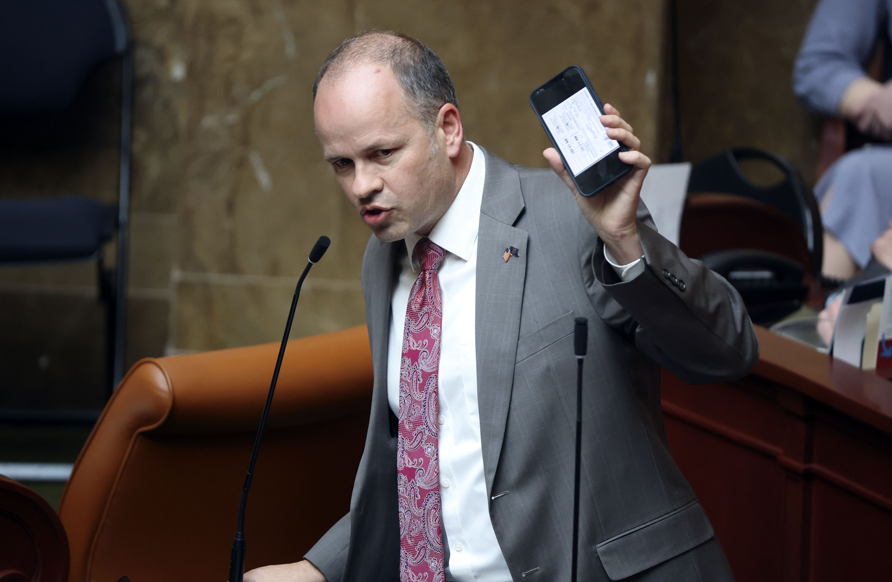 Rep. Timothy Hawkes, R-Centerville, shows his vaccination card on his phone while discussing HB60 at the Capitol in Salt Lake City on Tuesday. The bill would prohibit governments or employers from requiring vaccine passports.