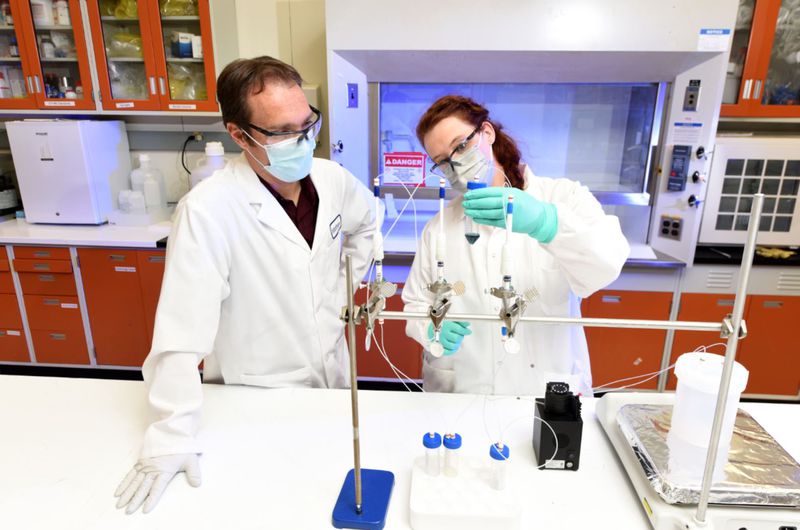 At a laboratory on the Idaho National Laboratory campus
in Idaho Falls, scientists Matt Snow and Jessica Ward hold a
natural vanadium solution that will be separated into the
cancer-treating isotope Scandium-47. The University of Utah and
Idaho National Laboratory announced a new research collaboration
agreement on Wednesday.