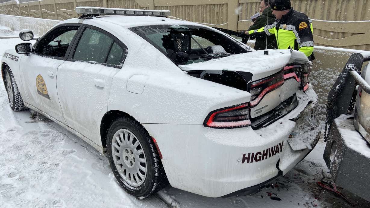 Two Utah Highway Patrol troopers suffered minor injuries Wednesday when the patrol car they were sitting in was hit by a pickup that lost control on I-15 and slid into the back of them in Orem.